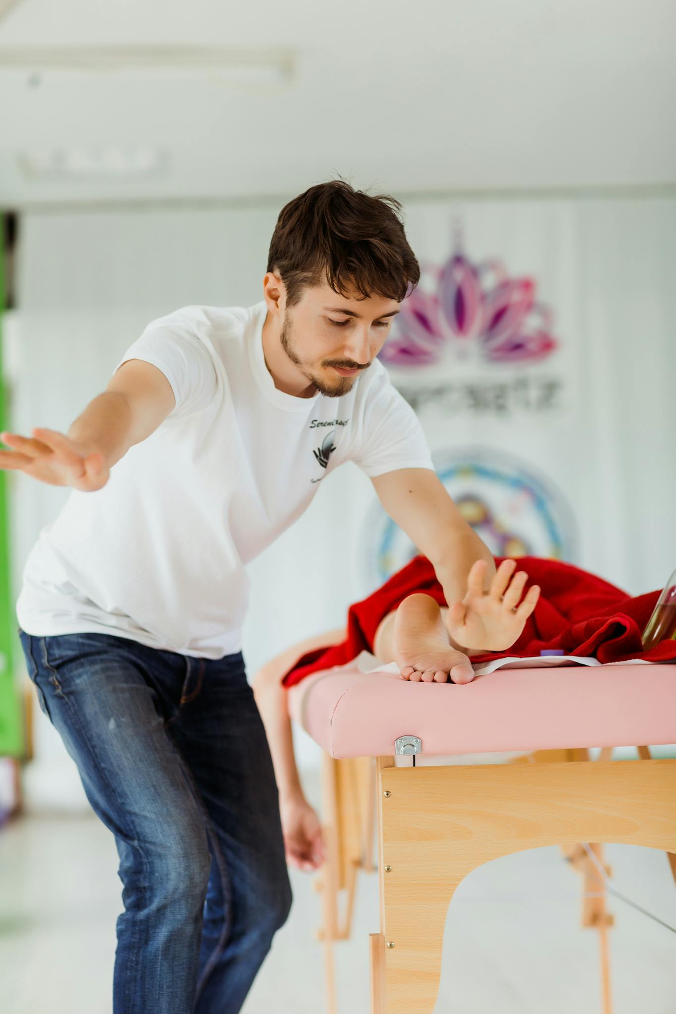 Male therapist performing a Reiki session indoors, enhancing relaxation and wellbeing.